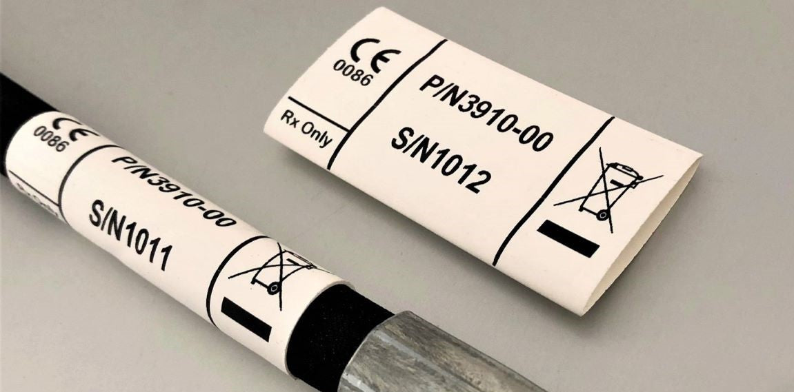 White heatshrink hose identification label printed with serial numbers and symbols